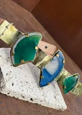 Cinturón artesanal de cuero con apliques metálicos y piedras naturales de ágata en tonos verdes y azules.