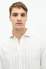 Camisa de manga larga de lino y algodón, color blanco con rayas verticales en tonos gris y beige. Presenta un corte semi slim y un pequeño logo bordado en el pecho.