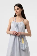 Vestido midi celeste de calce amplio y liviano, con escote fruncido regulable y breteles finos con detalles de cuentas. Presenta una silueta suelta e incluye una mini cartera desmontable al tono.