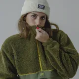 Buzo de sherpa color celeste con corte a la altura del pecho y bolsillo de nylon azul con logo estampado.