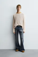 Jersey relaxed fit color beige, tejido en estructura abierta con calados, cuello redondo y manga larga.