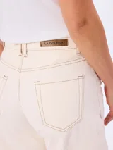 Jean de corte barrel color beige, de tiro medio y diseño amplio en las piernas con costuras pespunteadas a contratono.