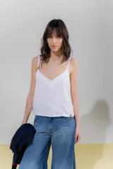 Top blanco de lino con escote en V y breteles regulables con detalle de borlas.