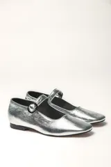 Zapato plano estilo Mary Jane de cuero negro, con punta fina y tira ajustable con hebilla sobre el empeine.