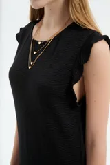 Vestido midi de poliéster color blanco, de corte recto y escote redondo a la base, con mangas cortas abuchonadas con volados y detalles de volados en el ruedo.