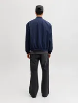 Campera bomber liviana color azul marino, con cuello baseball, cierre frontal de cremallera, bolsillos delanteros y puños de canalé.