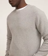 Suéter negro de tejido de punto maquinetado con cuello redondo y manga larga.