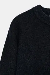 Jersey de punto de cuello redondo y manga larga, con textura jaspeada.