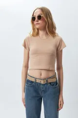 Top corto negro ajustado al cuerpo, de manga corta y cuello redondo.