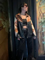 Campera de cuero sintético con cierre frontal, diseño de rombos en tonos marrón, beige y negro.