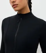 Campera deportiva de microfibra negra de la marca Get Over, con diseño ajustado, cuello alto, mangas largas, cierre frontal y bolsillos funcionales.