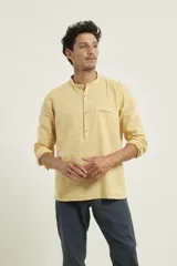 Camisa de lino con cuello mao y cierre frontal parcial con botones. Presenta manga larga y un bolsillo frontal en el pecho.