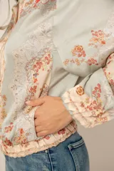 Campera liviana de satén con estampado floral y tropical, cierre frontal con cremallera, cuello mao y puños y cintura elásticos.