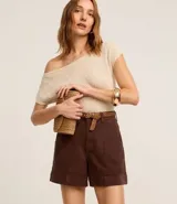 Short de mujer de sarga color beige claro, tiro alto, con pespunte contrastante en color blanco o crema. Presenta un corte regular y bolsillos delanteros y traseros.