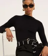 Blusa marrón de mangas largas, confeccionada en viscosa, con cuello redondo y sisas raglán.