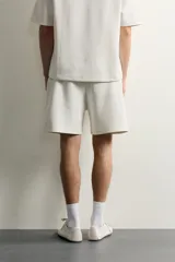 Bermuda estilo jogger de ajuste relajado, confeccionada en tejido interlock de algodón. Cuenta con cintura elástica ajustable con cordón, bolsillos frontales de vivo y diseño liso.