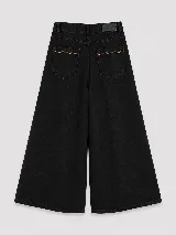 Pantalón de jean color naranja con tiro medio, diseño de pierna ancha y cinco bolsillos. Presenta costuras con pespuntes a contratono.