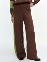 Pantalón de punto de pierna ancha, color marrón con franjas laterales en color verde. Presenta cintura elástica para un ajuste cómodo.