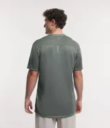 Remera deportiva de poliéster color gris claro, con cuello redondo, mangas cortas y recortes laterales de poliamida. Corte clásico.