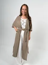 Saco tipo kimono color beige, confeccionado en hilo italiano, de manga corta y corte holgado. Incluye lazo para usar como choker o cinturón.