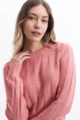 Sweater de punto color mostaza, con diseño de ochos y textura calada. Tiene cuello redondo, mangas largas y terminaciones acanaladas en puños y cintura.
