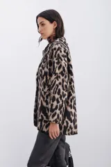 Tapado cruzado de corte oversize confeccionado en paño con estampado de leopardo. Presenta solapas clásicas, cierre frontal con botones y bolsillos aplicados.