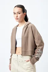 Canguro cropped negro con cierre frontal y estampa abstracta en contraste en las mangas.