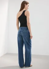 Jeans tiro medio de corte wide leg, confeccionados en 100% algodón, con diseño de cinco bolsillos, cierre de botón y cremallera, en color azul clásico con efecto deslavado.
