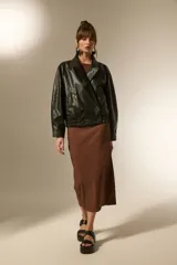 Campera estilo biker de eco-cuero color bordó, con cuello solapa ancho, manga larga y calce holgado. Presenta cierre frontal y botones decorativos en la parte inferior delantera.