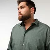 Camisa de corte recto y manga larga, color verde con estampado de pequeños puntos blancos. Presenta cuello clásico y cierre frontal con botones.