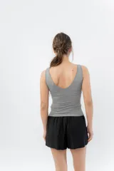 Top ajustado color gris claro, con escote en V pronunciado tanto en el frente como en la espalda, y tirantes anchos.