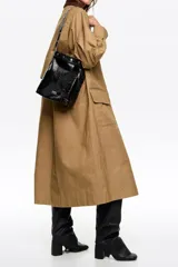 Bolso de hombro Bimba y Lola de tamaño mediano, confeccionado en piel vacuna con acabado brillante efecto arrugado. Presenta un diseño estructurado con asa larga decorada con tachas metálicas plateadas y cierre mediante botón de presión.