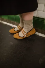 Chatitas color caramelo de gamuza, con puntera redondeada y doble tira sobre el empeine con hebillas circulares con strass.