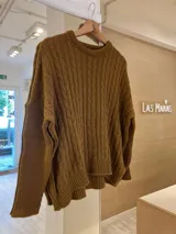 Sweater marrón de punto con cuello redondo y mangas largas. Tejido con diseño de trenzas en el frente.