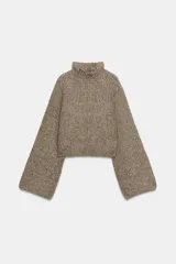 Jersey de punto con textura acanalada, cuello perkins y mangas largas acampanadas. Presenta un diseño corto con un borde inferior ancho y ajustado.