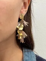 Aros colgantes de metal dorado con forma de pétalos de distintos colores.