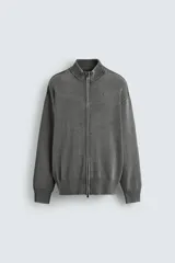 Chaqueta relaxed fit tejida en hilatura de algodón con efecto lavado, cuello subido y manga larga. Presenta acabados en rib y cierre frontal con cremallera.
