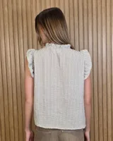 Musculosa a rayas verdes y blancas, con cuello alto fruncido, cierre frontal con botones y volados en los hombros.