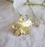 Anillo dorado con forma de flor de hibisco con textura arrugada.