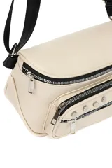 Riñonera de cuero sintético color beige, con correa ajustable negra, cierre principal superior y bolsillo frontal con cierre decorado con tachas metálicas.