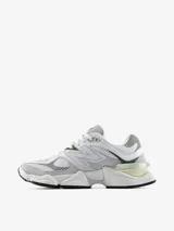 Championes New Balance modelo 9060, con diseño de inspiración Y2K. Presentan una parte superior de malla blanca con superposiciones de gamuza gris y detalles en verde y amarillo. Incluyen el logotipo N característico en los laterales, mediasuela con amortiguación ABZORB y SBS, y dispositivo CR translúcido en el talón.