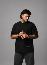 Remera boxy fit negra de algodón premium, de manga corta, con diseño amplio y detalle de logo estampado en el sector inferior trasero.