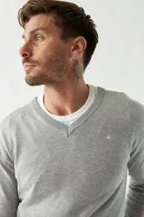 Sweater de punto color rosa con cuello en V y logo bordado en el pecho.