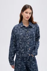 Campera de denim azul con estampado estilo paisley, cierre frontal con botones metálicos y cuello camisero.