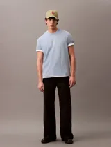 Remera de manga corta celeste con logo Calvin Klein Jeans bordado en amarillo en el centro del pecho.