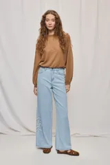 Jean wide leg blanco de tiro medio, con calce amplio y detalle de flores bordadas en los laterales.