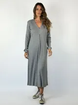 Vestido midi de punto acanalado en color gris, con escote en V, manga larga y un detalle de pliegue central en el frente que le otorga una caída fluida.