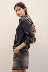 Camisa de denim gris oscuro efecto acid wash, de manga larga, con bolsillos frontales con solapa y broches metálicos a presión.