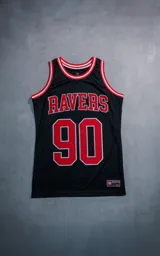 Musculosa deportiva estilo básquet color negro, con detalles de rib rojo y blanco en cuello y sisas. Presenta el texto 'RAVERS' y el número '90' estampados en rojo con borde blanco en el frente.