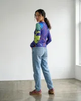Remera de manga larga con cuello redondo, confeccionada con una estampa exclusiva de formas orgánicas y abstractas en tonos azul, verde, turquesa y magenta.